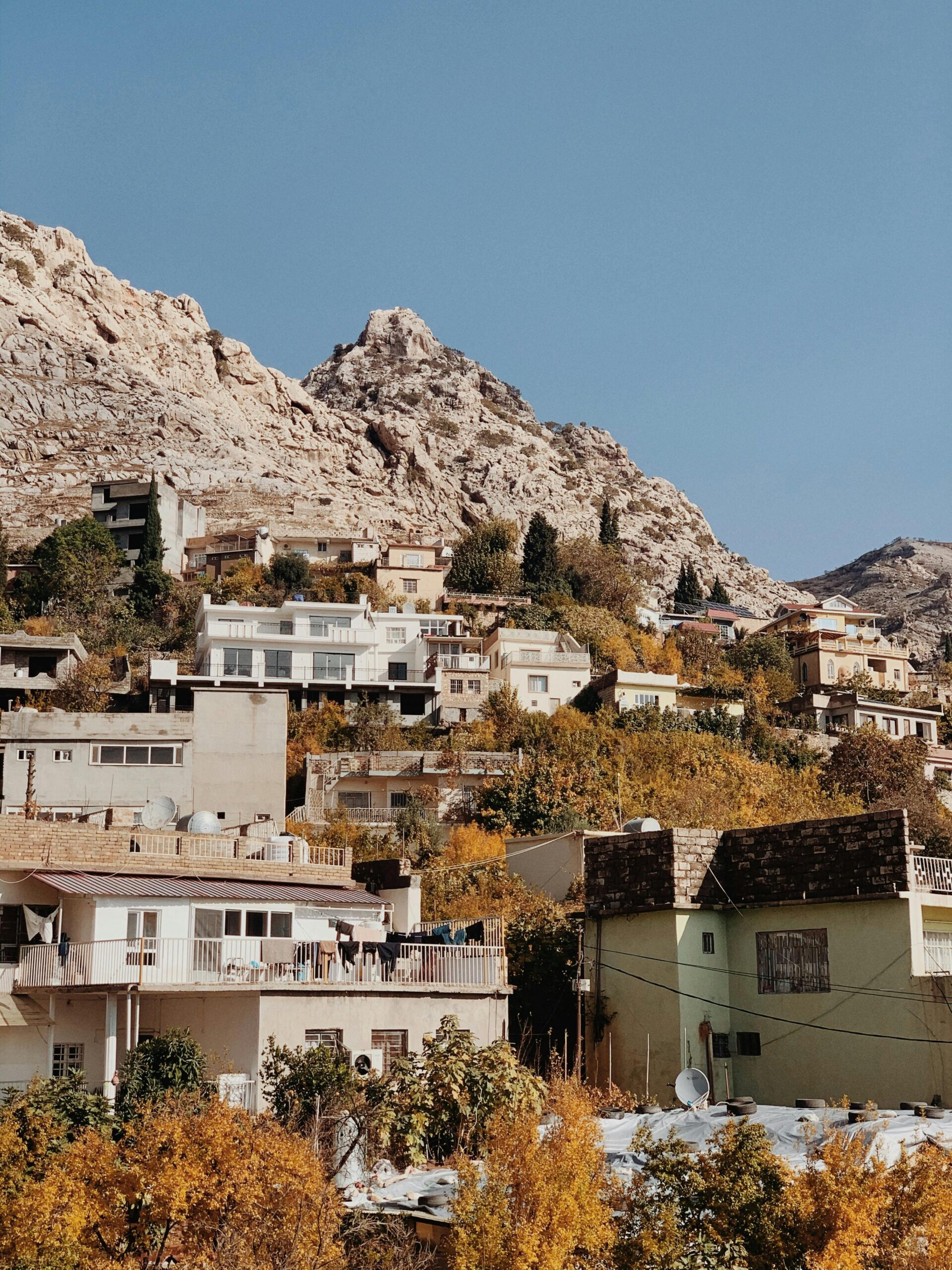 Autumn view of Amedi village, Iraq, with vibrant foliage against rugged mountains