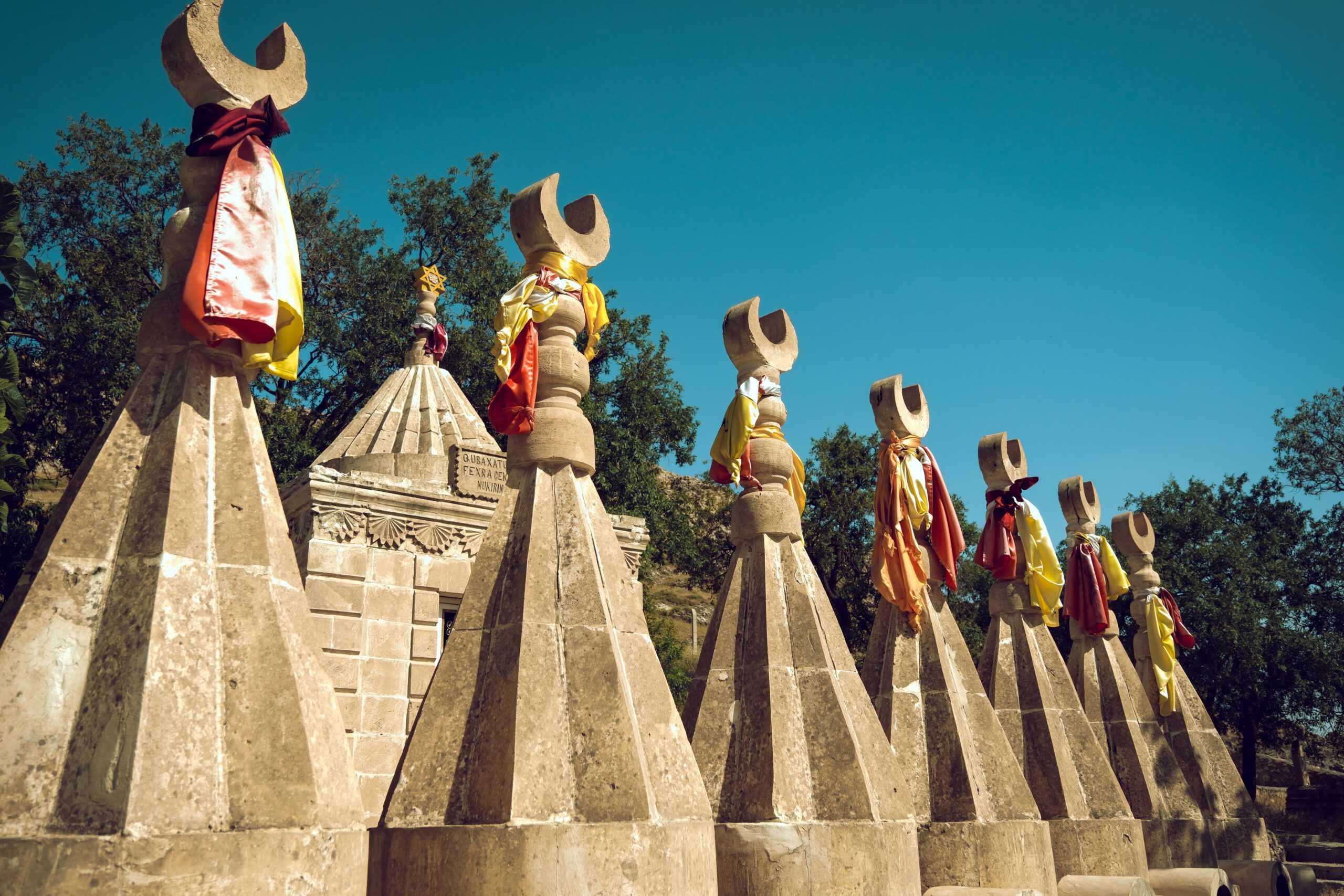 Sacred Yazidi sculptures adorned with colorful fabric in Mağaraköy, Şırnak, Türkiye.